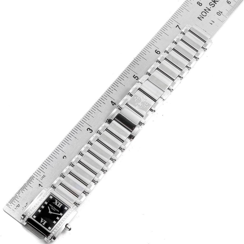 The Patek Philippe Twenty-4 4910 Women's Stainless Steel Black Dial 4910 Women's Stainless Steel Black Dial model watch is shown from a top view, displaying the face and metal bracelet against a ruler.