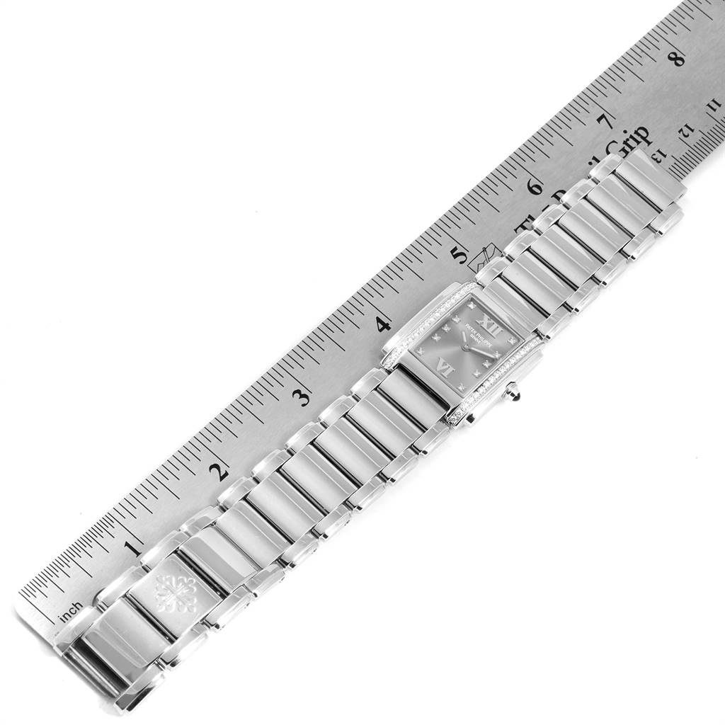 The Patek Philippe Twenty-4 4910/10A-010 Women's Stainless Steel Grey Dial 4910/10A-010 Women's Stainless Steel Grey Dial watch is shown from a top-down angle, placed alongside a ruler for scale.