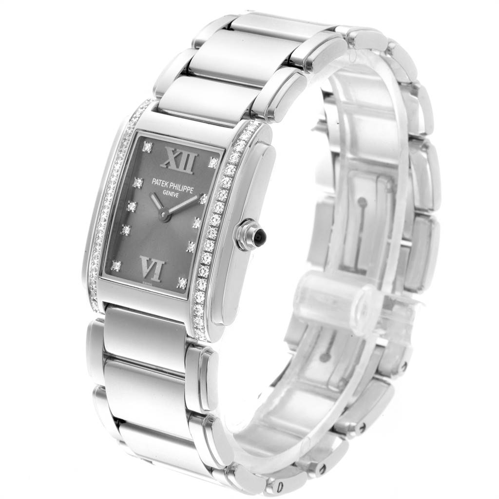 The image shows a Patek Philippe Twenty-4 4910/10A-010 Women's Stainless Steel Grey Dial 4910/10A-010 Women's Stainless Steel Grey Dial watch at a three-quarter angle highlighting the face, bezel, and bracelet.