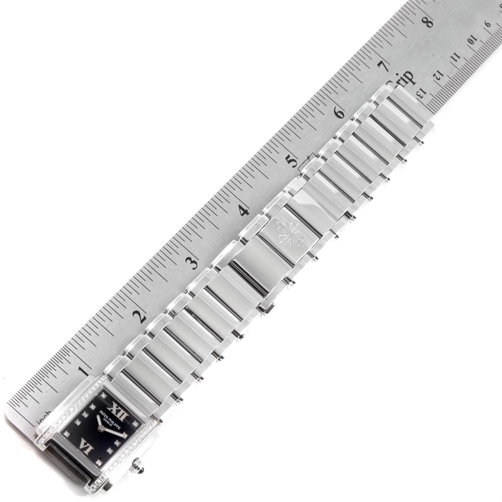 The image shows a Patek Philippe Twenty-4 4910-10A-001 Women's Stainless Steel Black Dial 4910-10A-001 Women's Stainless Steel Black Dial watch lying flat with its bracelet measured against a ruler.