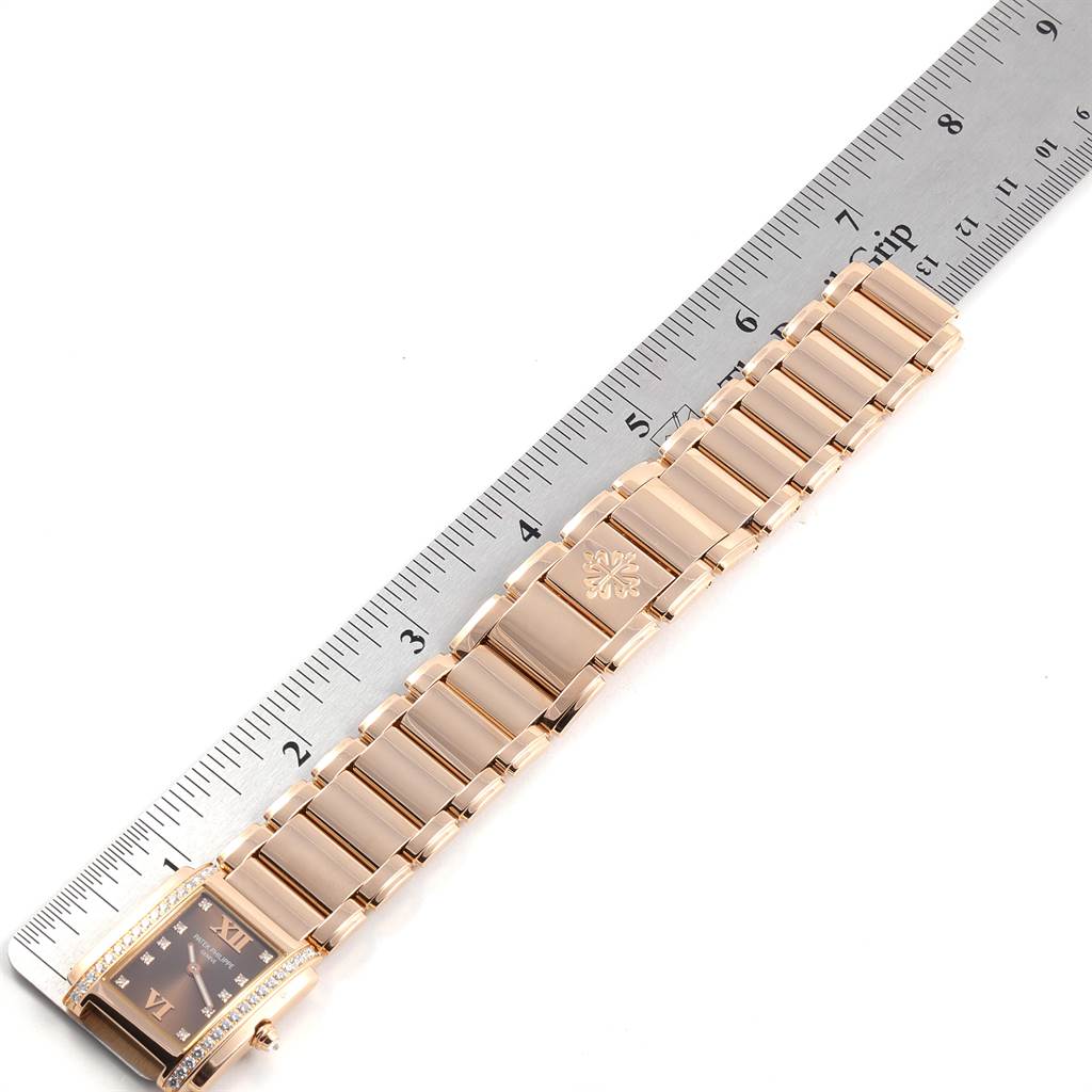 The image shows a Patek Philippe Twenty-4 4910/11R Women's Rose Gold Brown Dial 4910/11R Women's Rose Gold Brown Dial watch laid flat next to a ruler, displaying its bracelet and rectangular case.