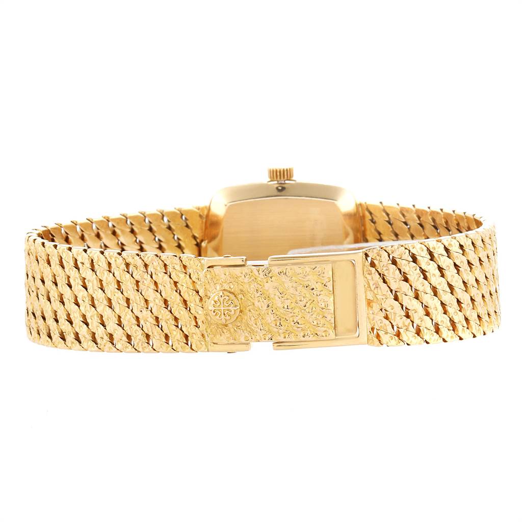 This image shows the back of a vintage Patek Philippe watch, highlighting its gold clasp and intricate bracelet design.