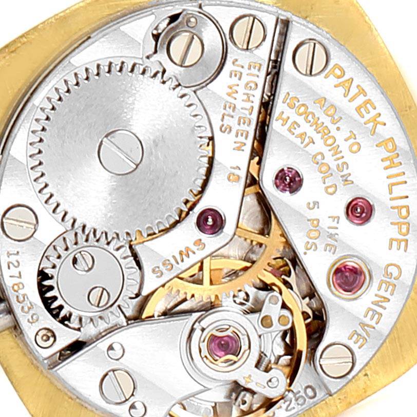 This image shows the intricate internal mechanism of a Vintage Patek Philippe watch, highlighting gears and jewels.