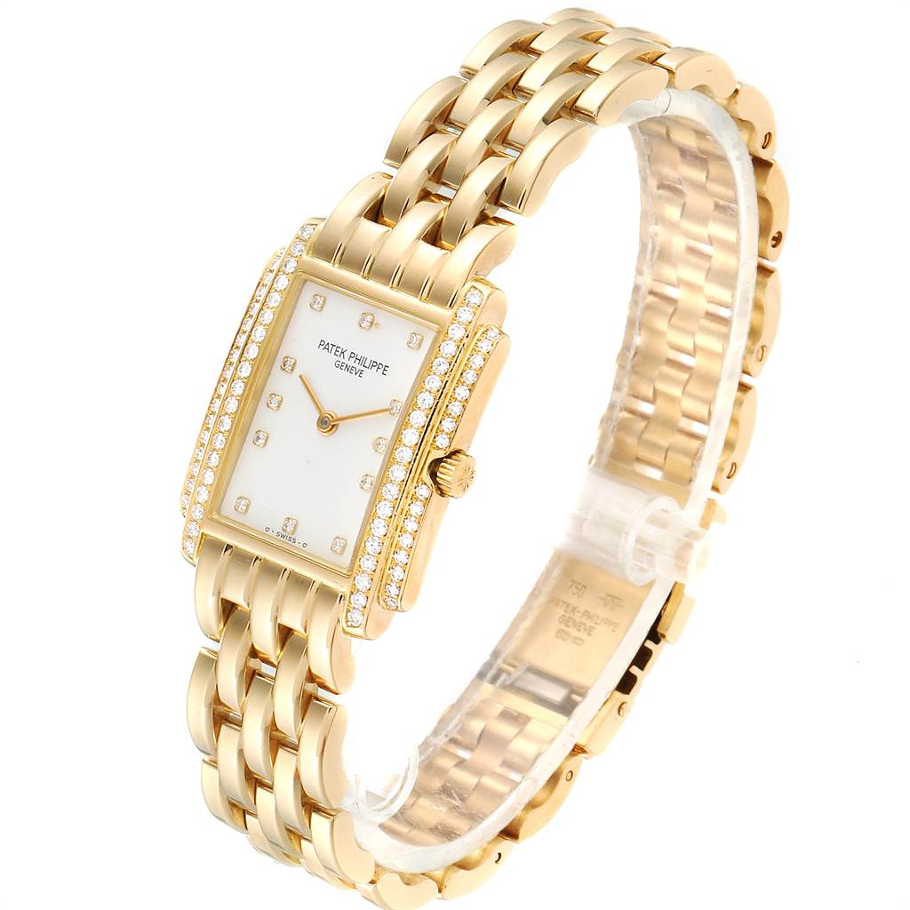 The image shows a side angle of the Patek Philippe Gondolo PATEK PHILIPPE Women's Yellow Gold White Dial PATEK PHILIPPE Women's Yellow Gold White Dial watch, highlighting its gold bracelet and diamond-studded rectangular face.