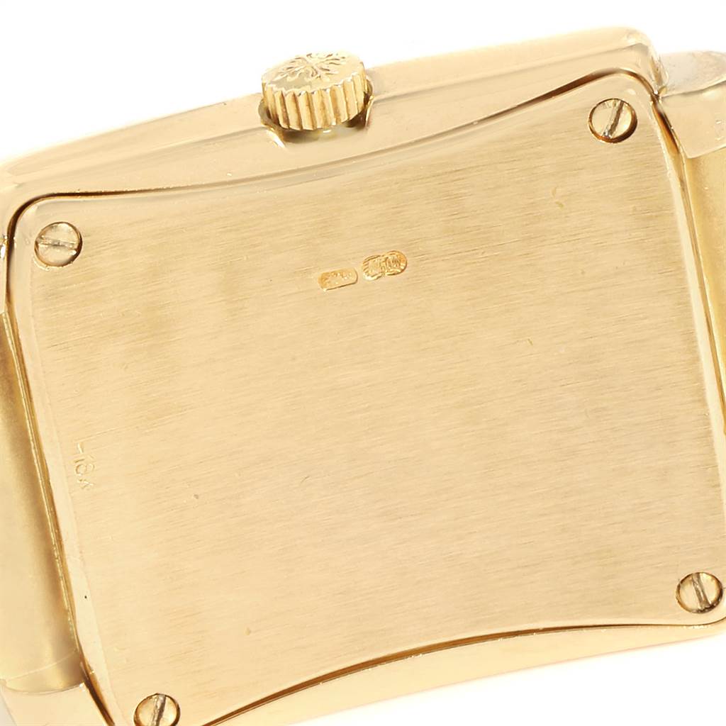 The image shows the back case and crown of a Patek Philippe Gondolo PATEK PHILIPPE Women's Yellow Gold White Dial PATEK PHILIPPE Women's Yellow Gold White Dial watch from a close-up angle.