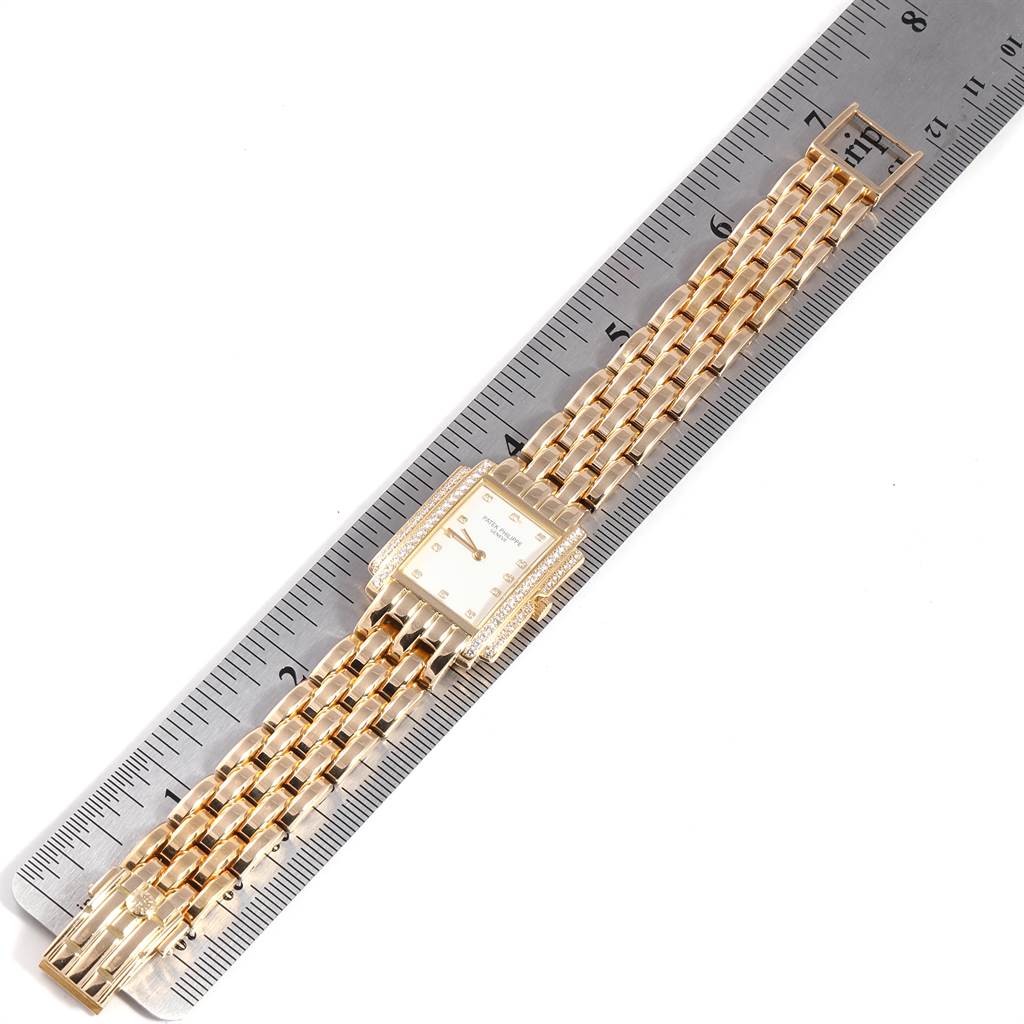 The image shows a top-down view of a Patek Philippe Gondolo PATEK PHILIPPE Women's Yellow Gold White Dial PATEK PHILIPPE Women's Yellow Gold White Dial watch, featuring its face and gold bracelet, measured against a ruler.