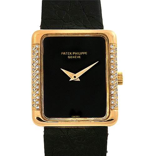 The image shows a front view of a vintage Patek Philippe watch with a rectangular black dial, gold case with diamond accents, and a black strap.