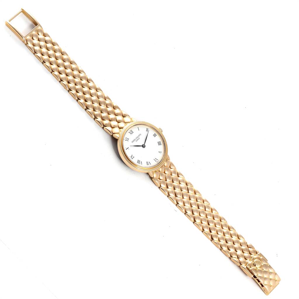 The image shows the Patek Philippe Calatrava 4819 Women's Yellow Gold White Dial 4819 Women's Yellow Gold White Dial watch in a flat, overhead view, highlighting the face, dial, and woven metal band.