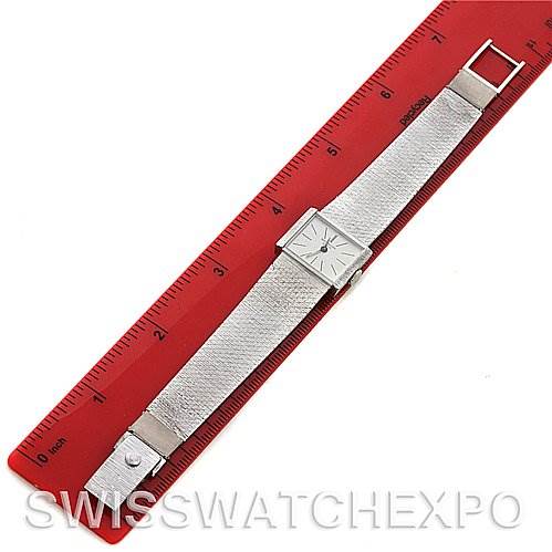 The image shows a top view of a Vintage Patek Philippe watch with a square dial on a textured strap beside a red ruler.