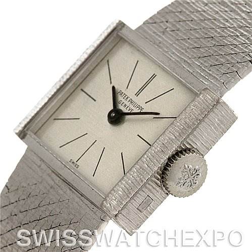 This image shows a vintage Patek Philippe watch angled from the front-left, highlighting the square dial and textured strap.