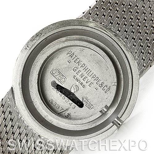 This image shows the inner case back of a vintage Patek Philippe watch with detailed engravings and mesh strap partially visible.