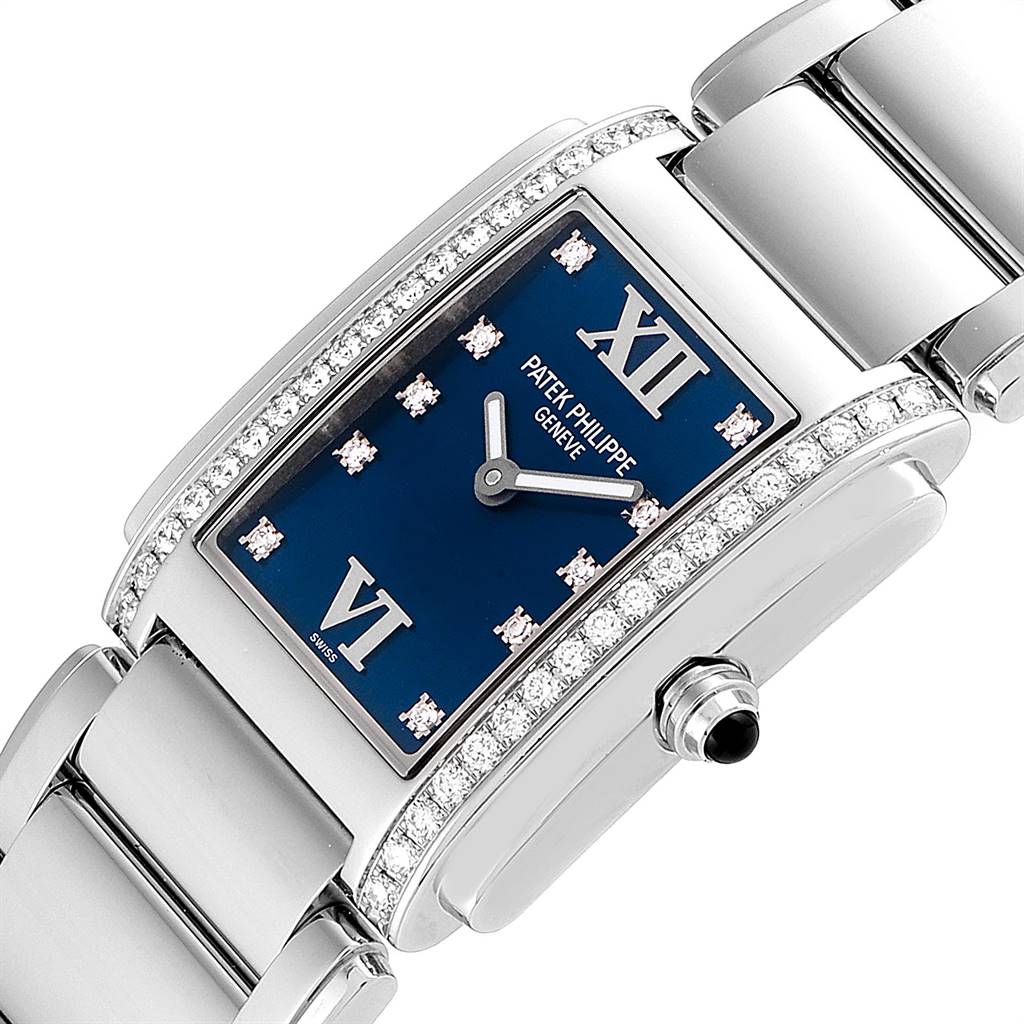 The image shows a close-up angle of the Patek Philippe Twenty-4 4910-10A-012 Women's Stainless Steel Blue Dial 4910-10A-012 Women's Stainless Steel Blue Dial watch highlighting the blue dial, diamond bezel, and metal bracelet.