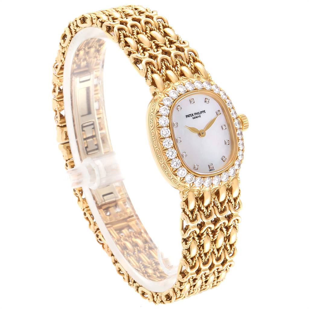 The image shows a side-angle view of the Patek Philippe Golden Ellipse 4931/2 Women's Yellow Gold Mother of Pearl Dial 4931/2 Women's Yellow Gold Mother of Pearl Dial watch, highlighting its ornate gold bracelet and diamond-studded bezel.