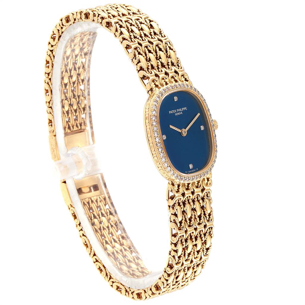 The image shows a Patek Philippe Golden Ellipse 4698/1 Women's Yellow Gold Blue Dial 4698/1 Women's Yellow Gold Blue Dial watch at a 3/4 angle, highlighting its blue dial, gold bracelet, and diamond bezel.
