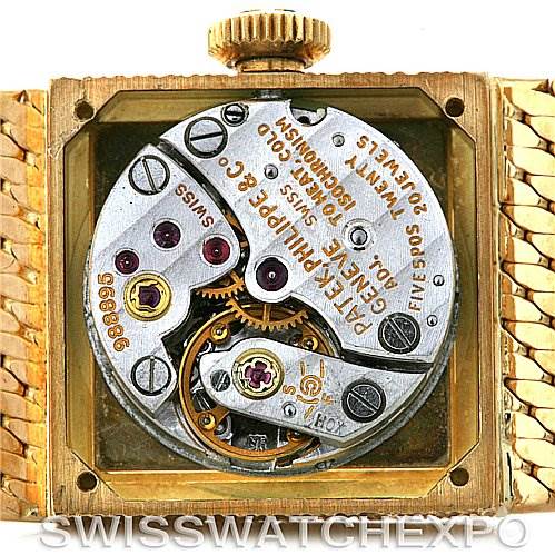 This image shows the internal mechanism of a vintage Patek Philippe watch, highlighting its intricate gears and movement from a back angle.