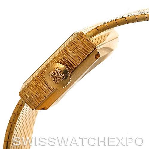 The image shows a side view of the case and crown of a Vintage Patek Philippe watch, featuring a gold band and intricate detailing.