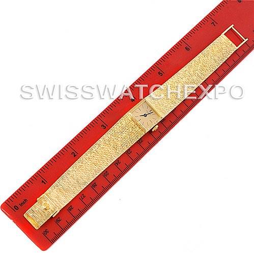The image shows a top-down view of a Vintage Patek Philippe watch laid out next to a red ruler for scale.