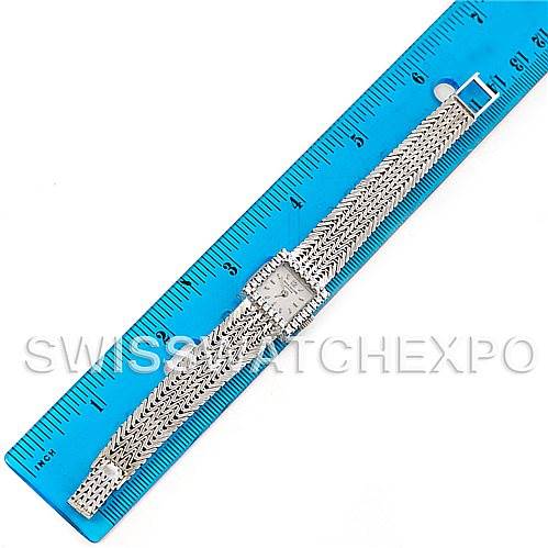 This image shows a Patek Philippe Vintage 3293/1 Women's White Gold Silver Dial 3293/1 Women's White Gold Silver Dial watch laid flat next to a blue ruler, displaying the band and square watch face.