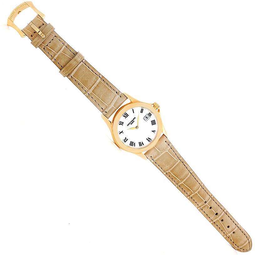 The image shows a top-down view of the Patek Philippe 4906J Women's Yellow Gold White Dial 4906J Women's Yellow Gold White Dial 18k Yellow Gold Ladies Watch 4906J, displaying the face and beige leather strap.