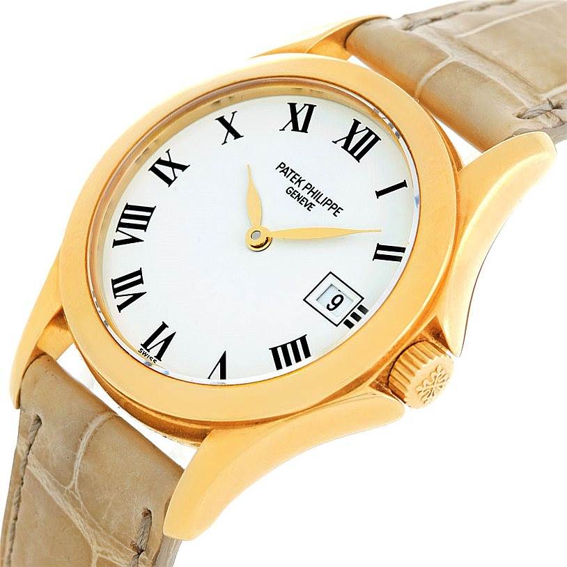 The image displays the Patek Philippe 4906J Women's Yellow Gold White Dial 4906J Women's Yellow Gold White Dial 18k Yellow Gold Ladies Watch 4906J model from an angled top view, highlighting the face, bezel, and crown.