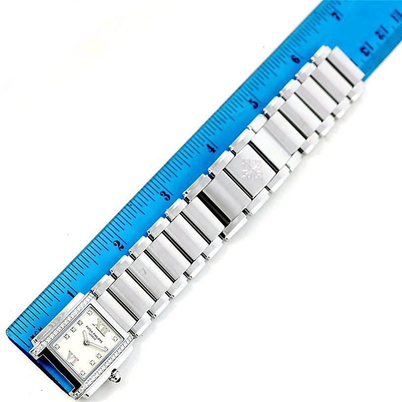 The Patek Philippe Twenty-4 4910/10A-011 Women's Stainless Steel Silver Dial 4910/10A-011 Women's Stainless Steel Silver Dial watch is shown from a top-down angle, with the dial and full bracelet visible next to a ruler.