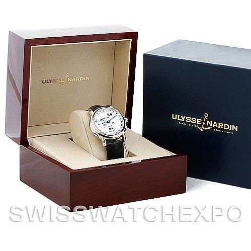 The Ulysse Nardin 329-80 Men's Platinum Silver Dial 329-80 Men's Platinum Silver Dial GMT Perpetual Platinum 329-80 Limited Edition Men's Watch is displayed at an angle inside an open wooden box next to a blue box.