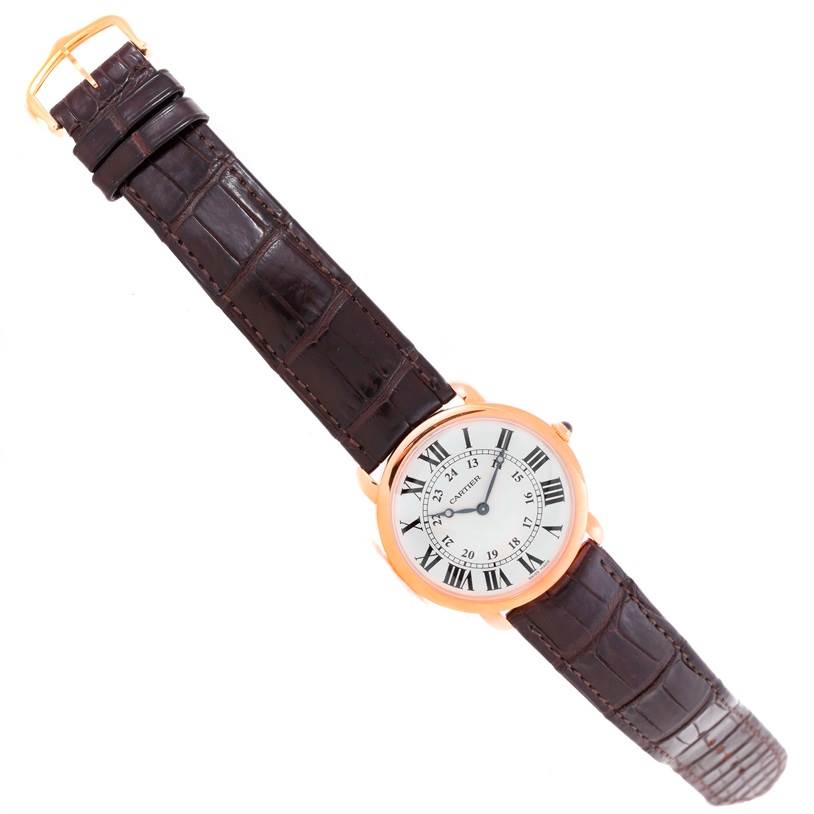 The image shows a top-down view of a Cartier Ronde W6800251 Men
s Rose Gold Silver Dial W6800251 Men
s Rose Gold Silver Dial watch with a brown leather strap and a round white dial with black Roman numerals.