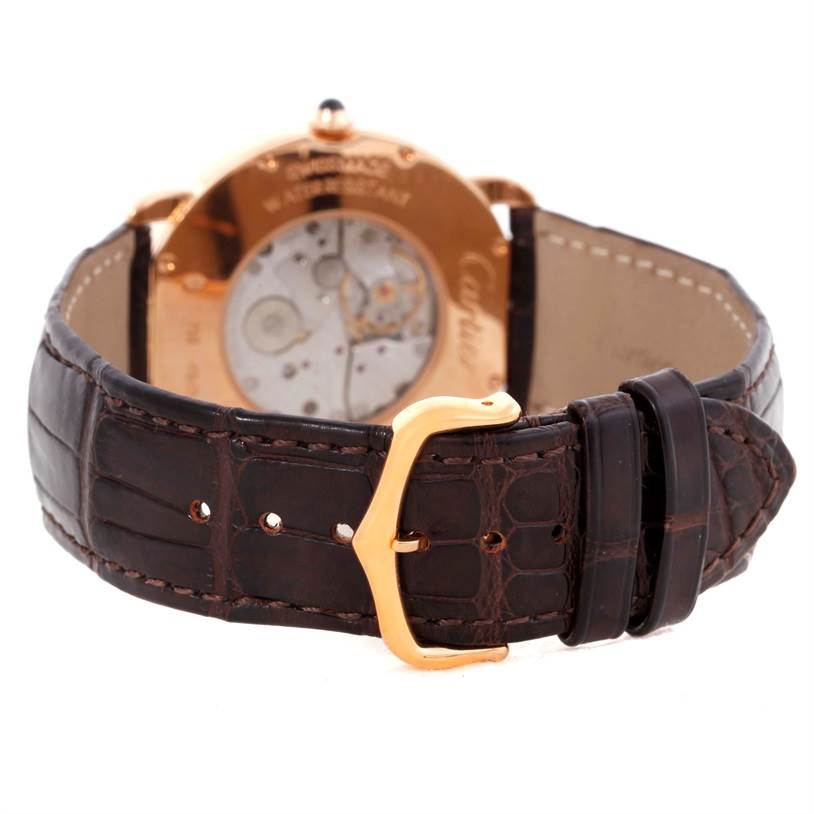 This image shows the back view of a Cartier Ronde W6800251 Men
s Rose Gold Silver Dial W6800251 Men
s Rose Gold Silver Dial watch, highlighting its movement through a display case and its brown leather strap.