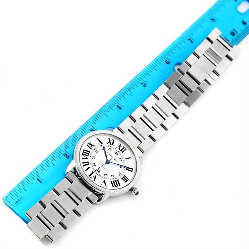 The image shows a Cartier Ronde W6701011 Men's Stainless Steel Silver Dial W6701011 Men's Stainless Steel Silver Dial watch laid flat on a surface next to a ruler, displaying its face and metal bracelet.
