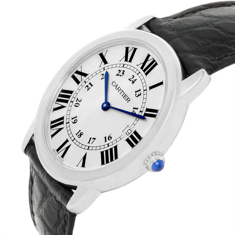 The image shows a Ronde model by Cartier from a three-quarter angle, highlighting the watch face, leather strap, and crown with a blue stone.