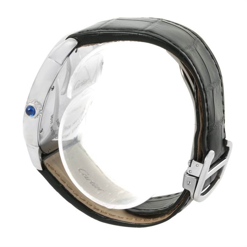 The image shows a side view of the Ronde model by Cartier, highlighting its crown with a blue cabochon and black leather strap.