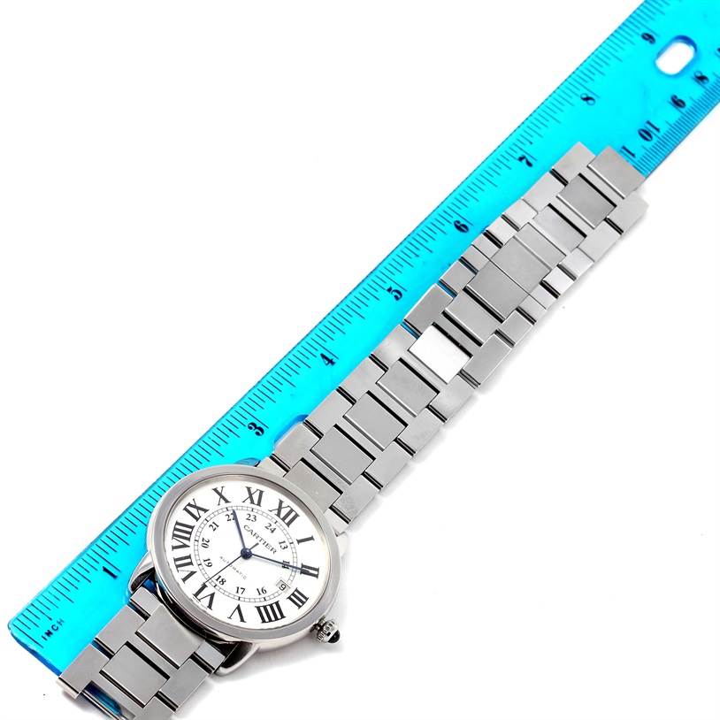 The image depicts a Cartier Ronde W6701011 Men's Stainless Steel Silver Dial W6701011 Men's Stainless Steel Silver Dial watch laid flat with a blue ruler alongside, showing both the face and the full length of the metal bracelet.