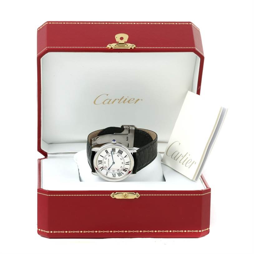 The Ronde model by Cartier is shown at a front angle inside a red Cartier box with a nearby booklet.