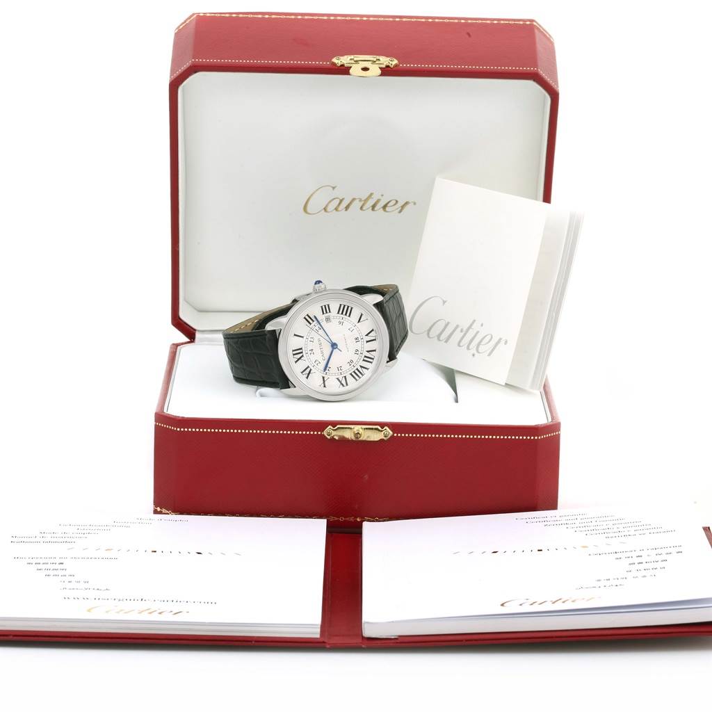 The Cartier Ronde W6701010 Men
s Stainless Steel Silver Dial W6701010 Men
s Stainless Steel Silver Dial watch is displayed at an angle showing the face and band, inside its open box with booklets beside it.