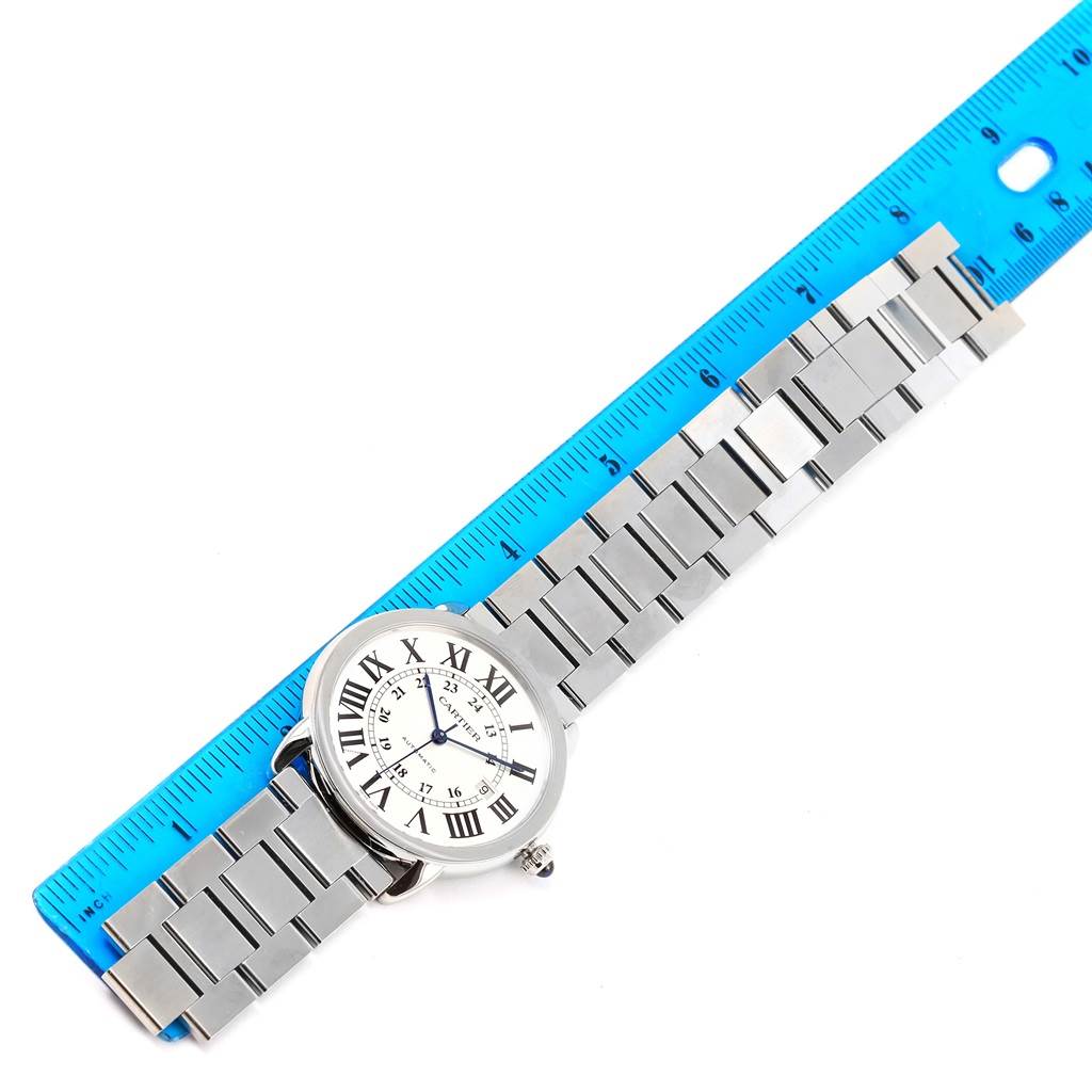 The image shows a Cartier Ronde W6701011 Men's Stainless Steel Silver Dial W6701011 Men's Stainless Steel Silver Dial model watch laid next to a blue ruler, displaying its face and metal bracelet.