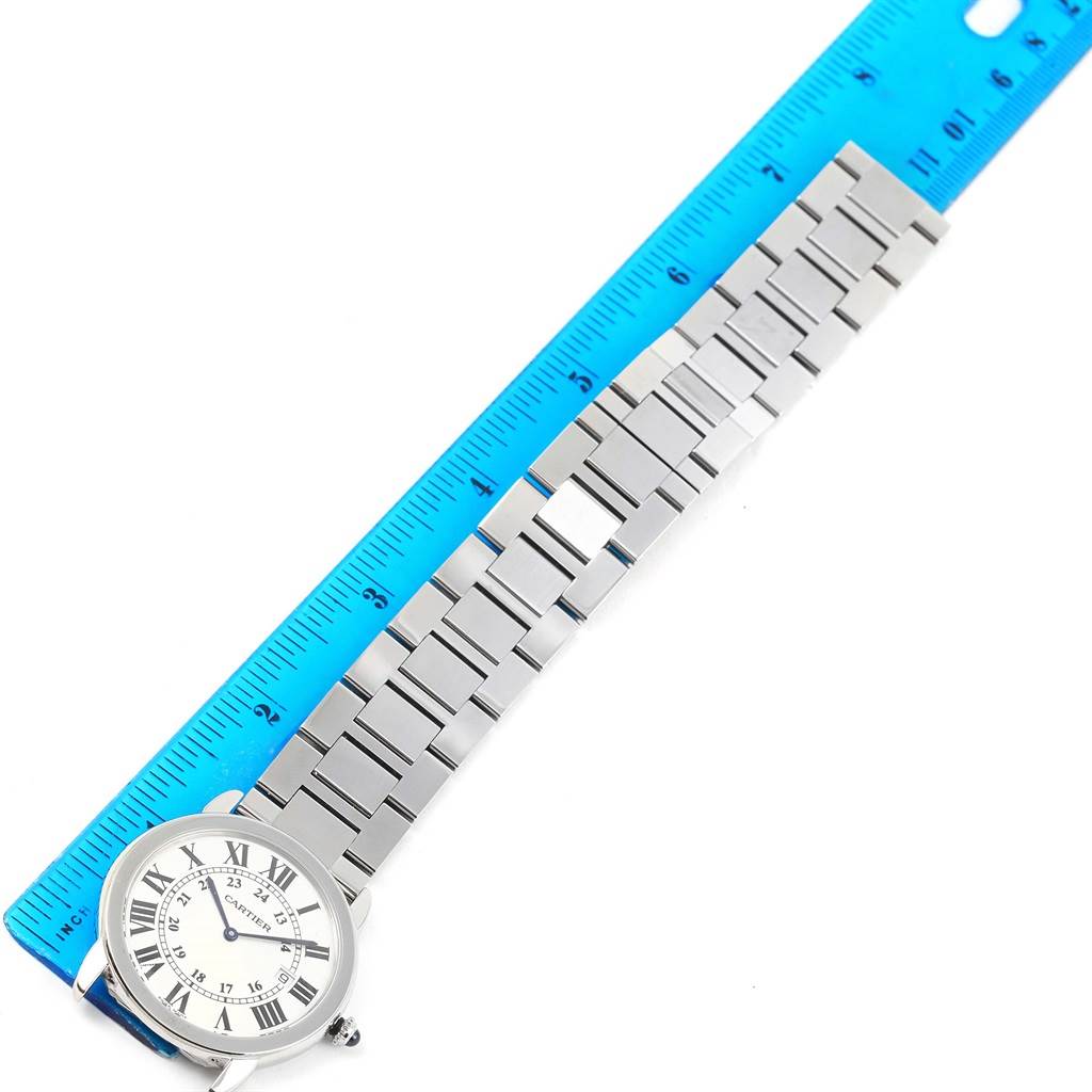 The image shows a Cartier Ronde W6701005 Men
s Stainless Steel Silver Dial W6701005 Men
s Stainless Steel Silver Dial model watch laid flat with its metal bracelet beside a blue ruler for measurement.
