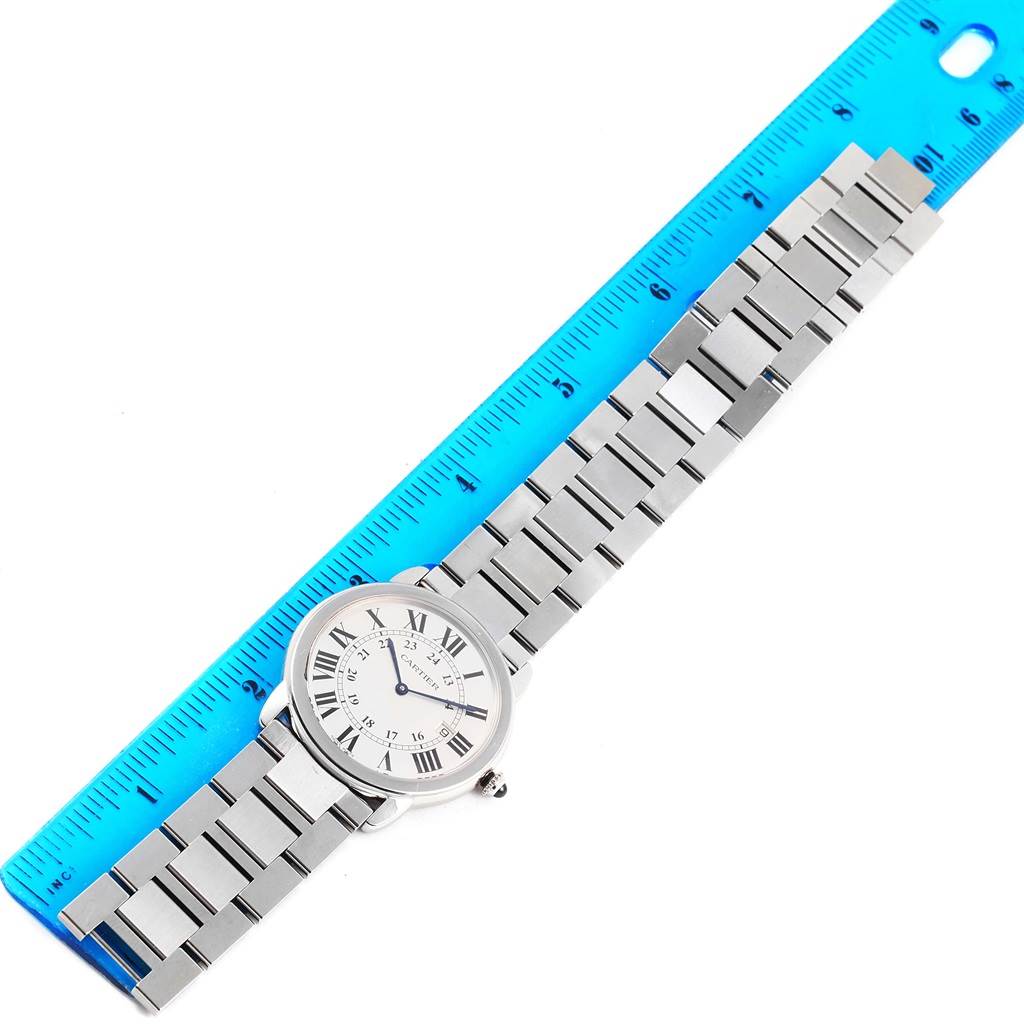 The Cartier Ronde W6701005 Stainless Steel Silver Dial W6701005 Stainless Steel Silver Dial watch is displayed flat with its entire face and metal bracelet visible, alongside a blue ruler for measurement.