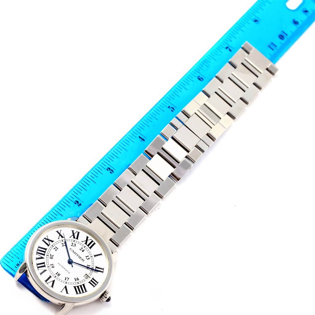 The image shows a Cartier Ronde W6701011 Men
s Stainless Steel Silver Dial W6701011 Men
s Stainless Steel Silver Dial watch laid flat, face-up, next to a blue ruler for measurement.