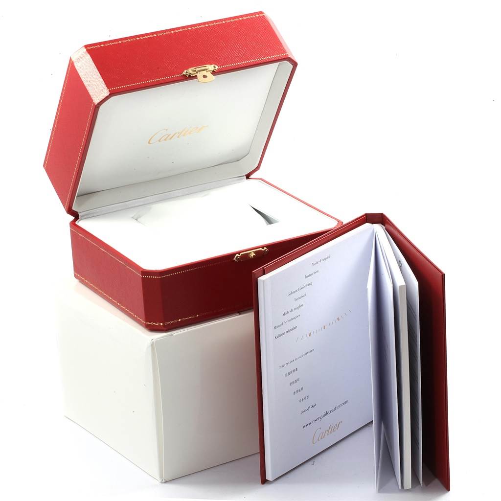 The image shows an open red Cartier Ronde W6701011 Men
s Stainless Steel Silver Dial W6701011 Men
s Stainless Steel Silver Dial watch box and an accompanying booklet.