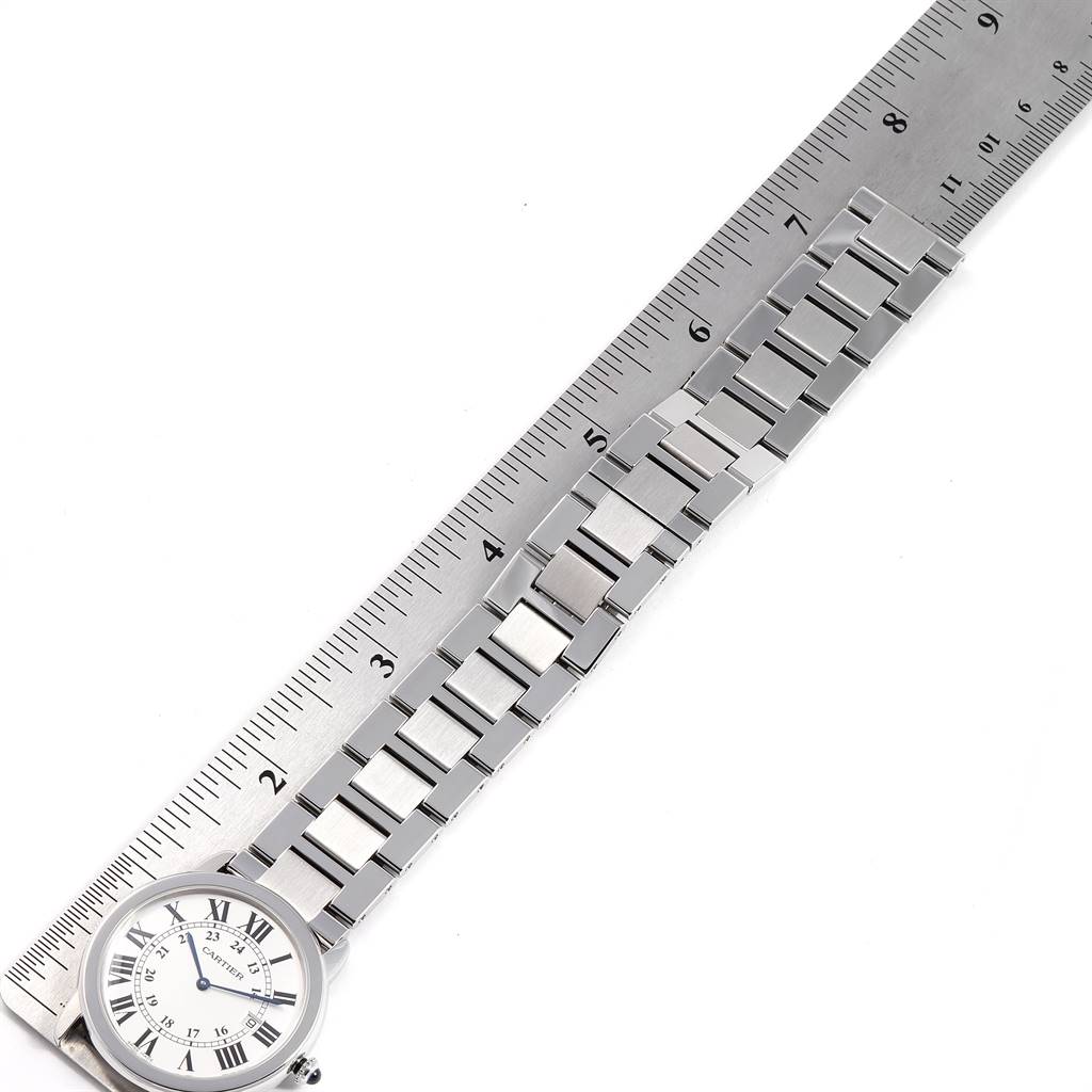 This image shows a Cartier Ronde W6701005 Men's Stainless Steel Silver Dial W6701005 Men's Stainless Steel Silver Dial watch laid flat next to a ruler, displaying the watch face and metal bracelet links.