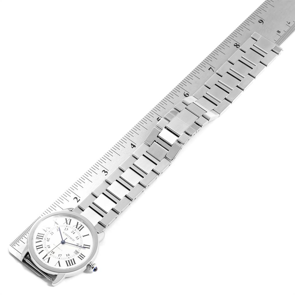 This image shows the Cartier Ronde W6701011 Men's Stainless Steel Silver Dial W6701011 Men's Stainless Steel Silver Dial watch placed on a ruler, displaying its face and metal bracelet at an angle.