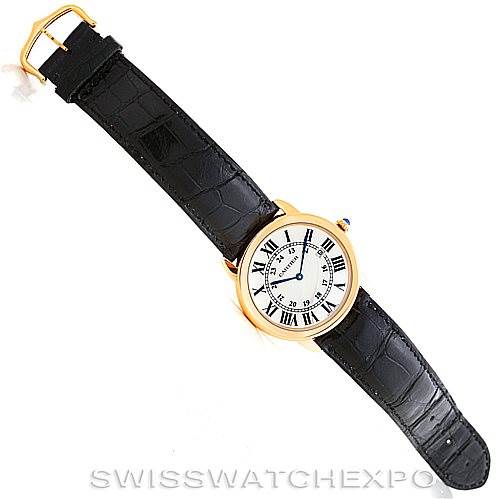 The image shows a top-down view of a Ronde model Cartier watch with a black leather strap and a gold case.