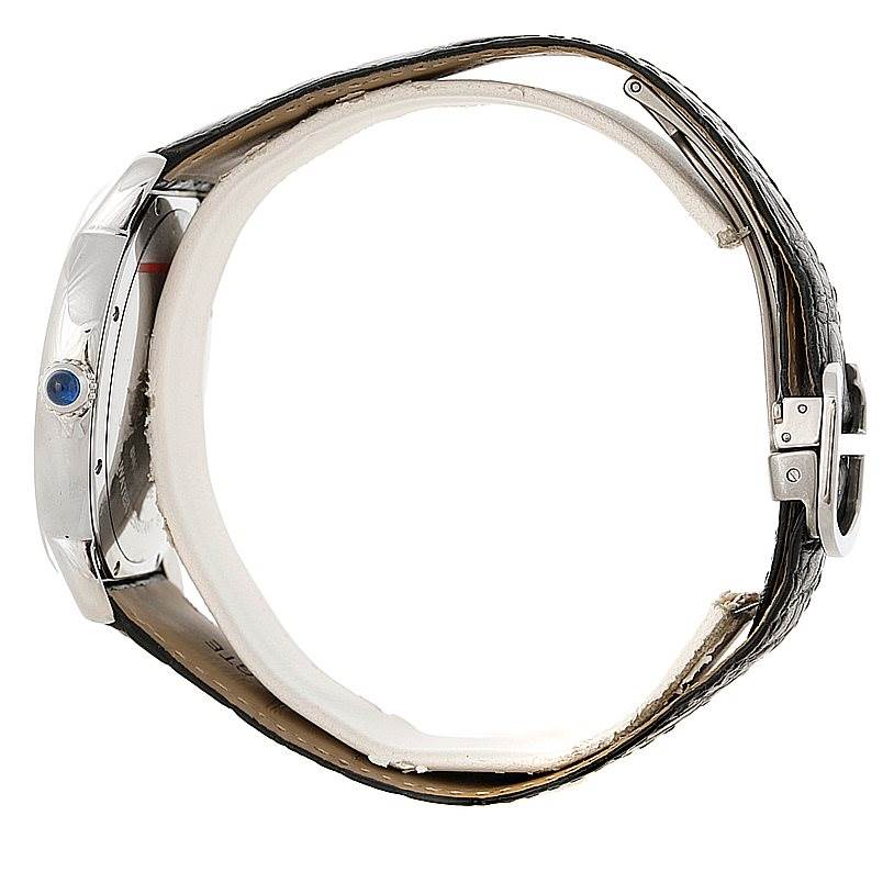 This side-view image of the Cartier Ronde W6701010 Men's Stainless Steel Silver Dial W6701010 Men's Stainless Steel Silver Dial model shows the watch case, the crown with a blue gem, and a partially fastened leather strap.