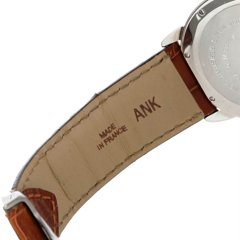 The image shows the back case and a portion of the leather strap of a Ronde model watch by Cartier, viewed from an angle highlighting the underside.