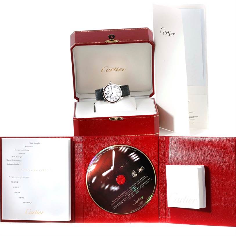 The image shows a Cartier Ronde W6700255 Stainless Steel Silver Dial W6700255 Stainless Steel Silver Dial watch in its open box, along with the warranty booklet, manual, and a DVD.