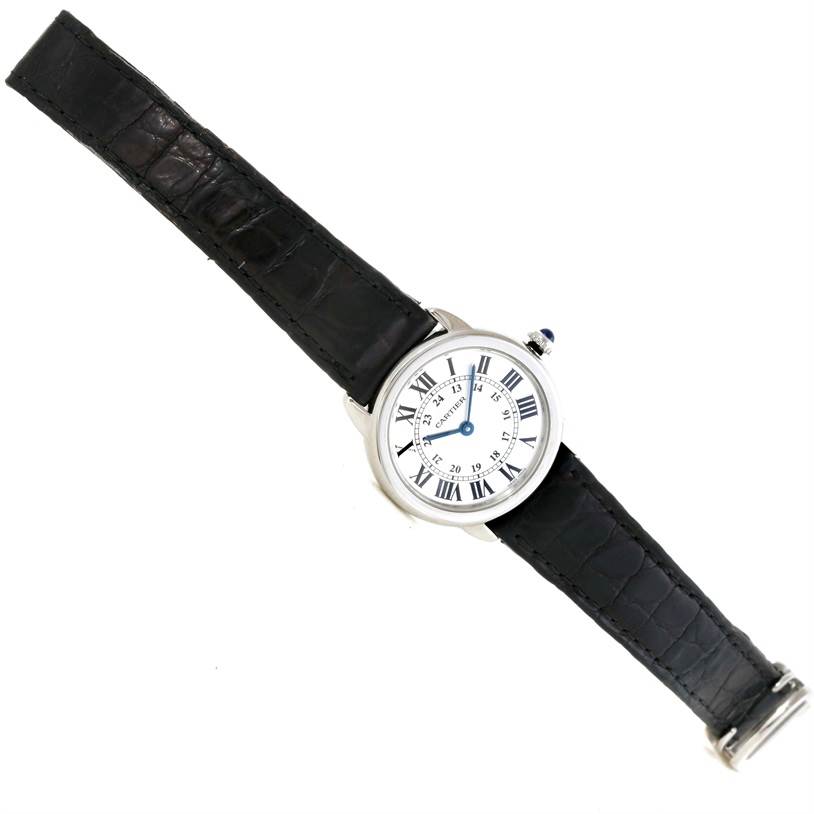 The Ronde model by Cartier is shown in a direct overhead view, displaying the watch face and black leather strap.