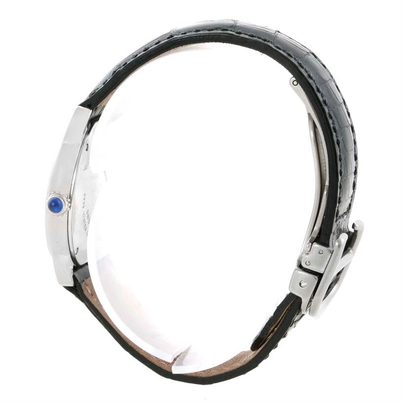 The image shows a side view of a Cartier Ronde W6700155 Women
s Stainless Steel Silver Dial W6700155 Women
s Stainless Steel Silver Dial model watch with a black leather strap and a visible blue gem on the crown.