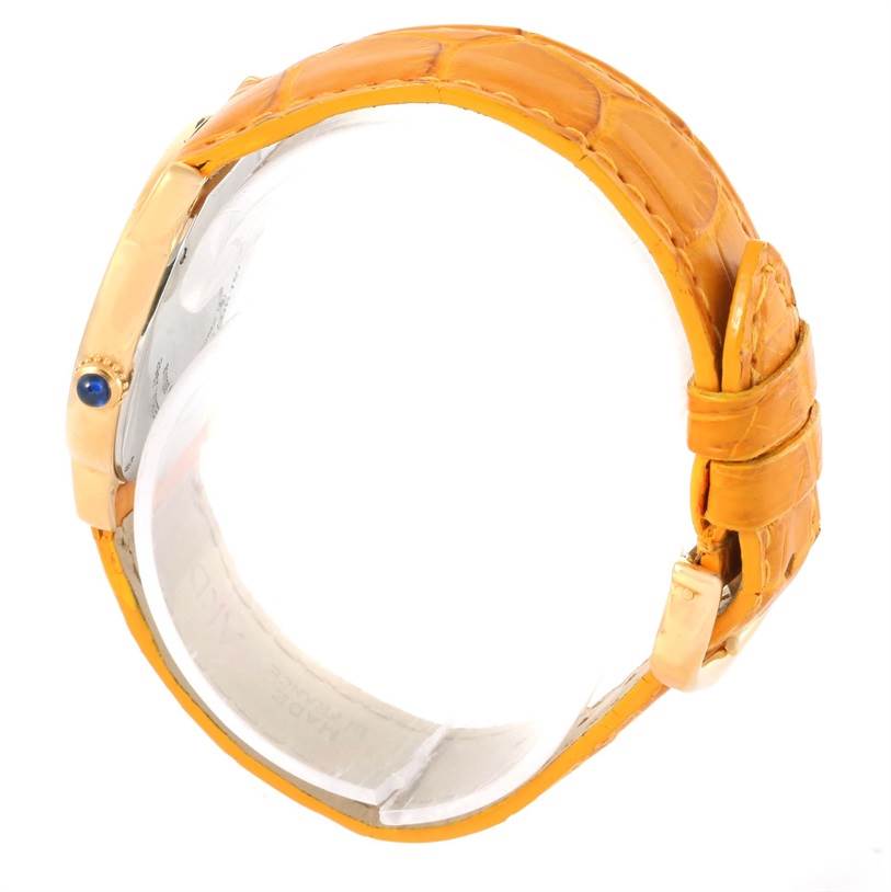 This side view of the Cartier Ronde W6700355 Women's Steel and Gold (two tone) Silver Dial W6700355 Women's Steel and Gold (two tone) Silver Dial watch showcases its orange strap and crown with a blue gem.