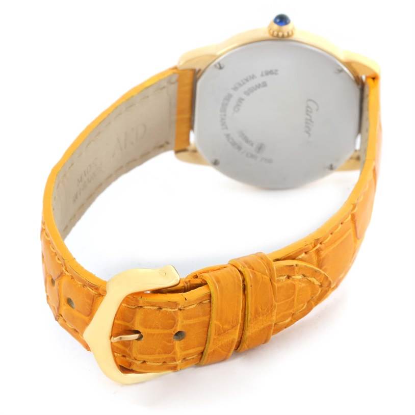 The image shows the back of the Cartier Ronde W6700355 Women's Steel and Gold (two tone) Silver Dial W6700355 Women's Steel and Gold (two tone) Silver Dial watch and its orange leather strap.