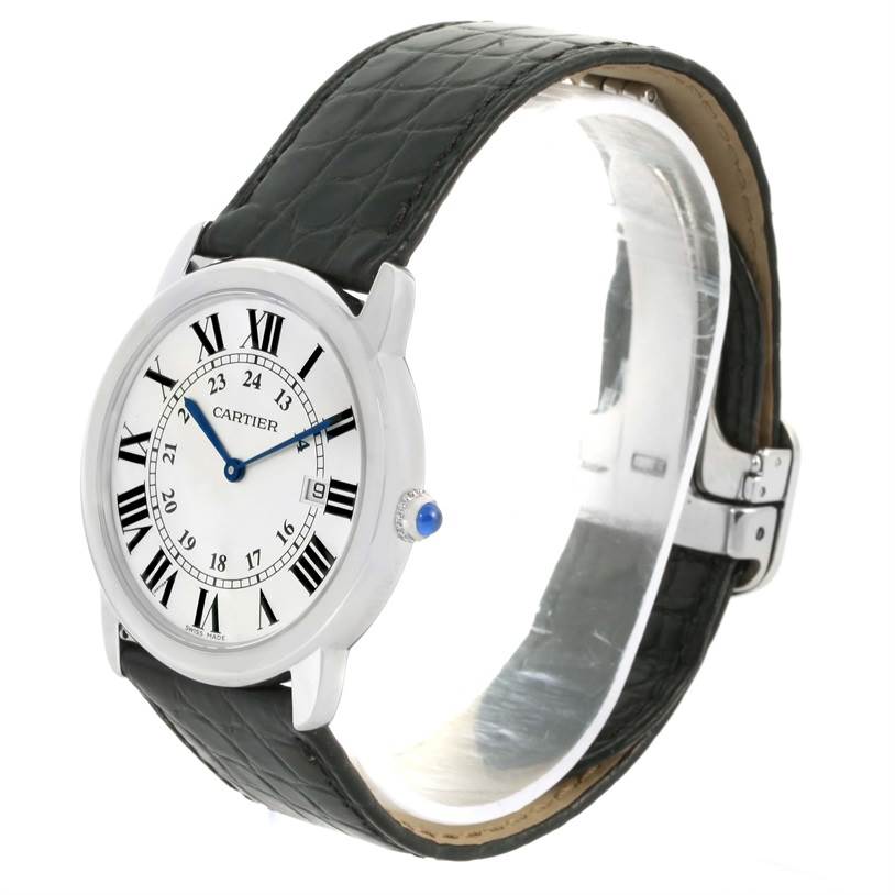 The image shows a side view of the Cartier Ronde W6700255 Stainless Steel Silver Dial W6700255 Stainless Steel Silver Dial watch, highlighting its dial, Roman numerals, strap, and crown with a blue cabochon.